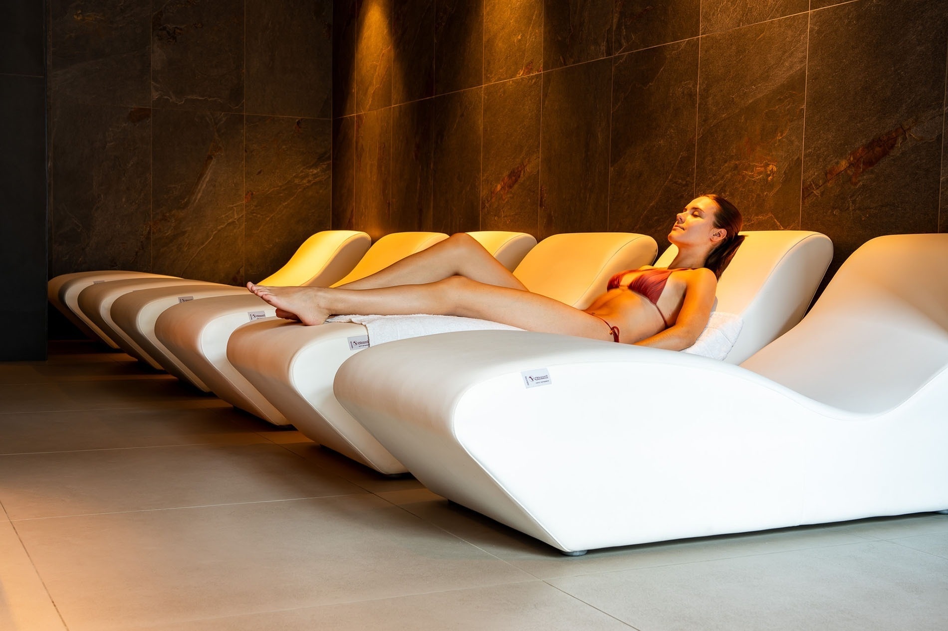 una mujer se sienta en una sauna con luces rojas y azules