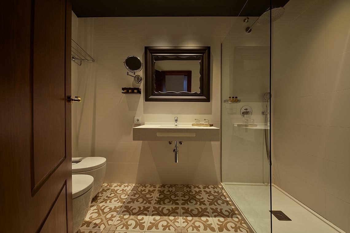 un baño con inodoro , lavabo , espejo y ducha