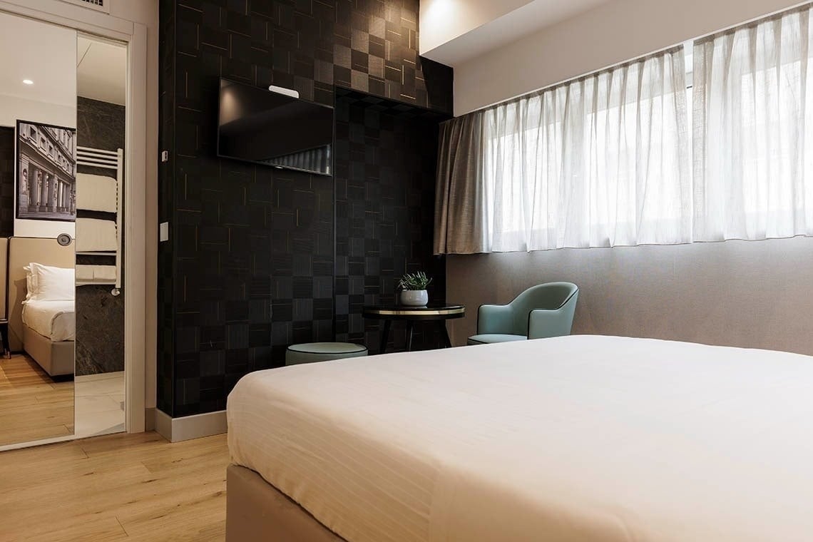 una camera d' albergo con un letto e una sedia