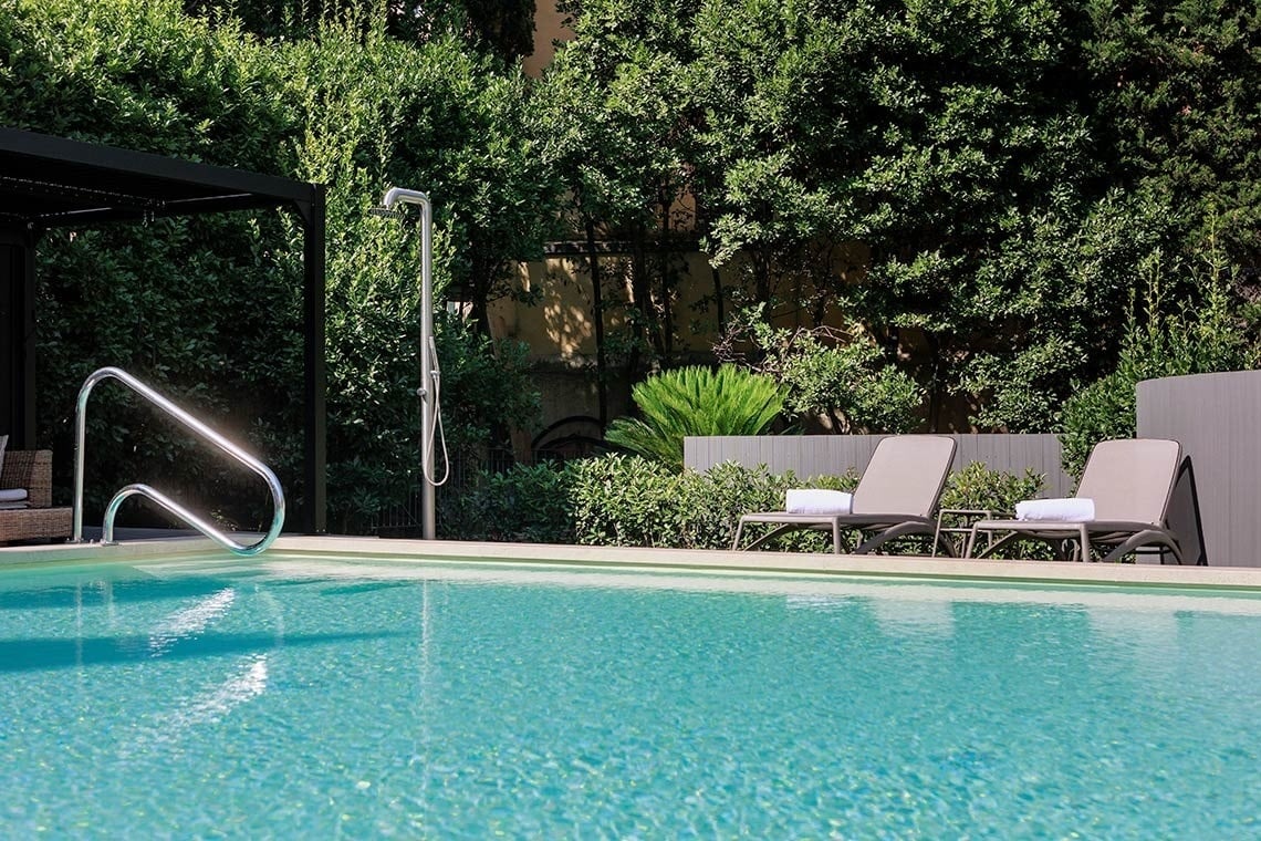 una mujer envuelta en una toalla está sentada en una ducha de vapor .