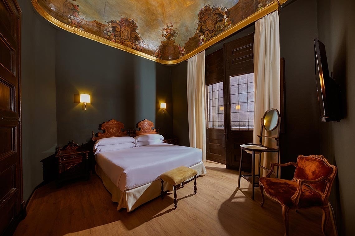 una habitación oscura con una cama y una silla