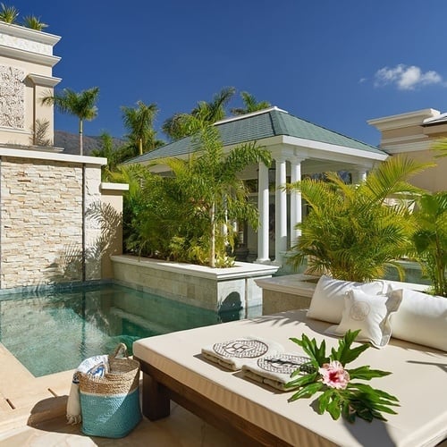 ein weißes Bett neben einem kleinen Swimmingpool