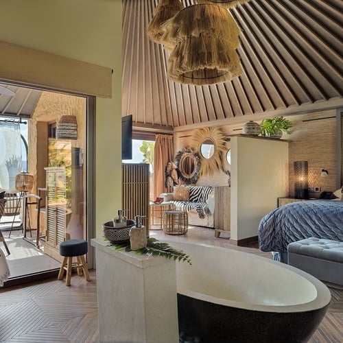 a bedroom with a bathtub in the middle of it