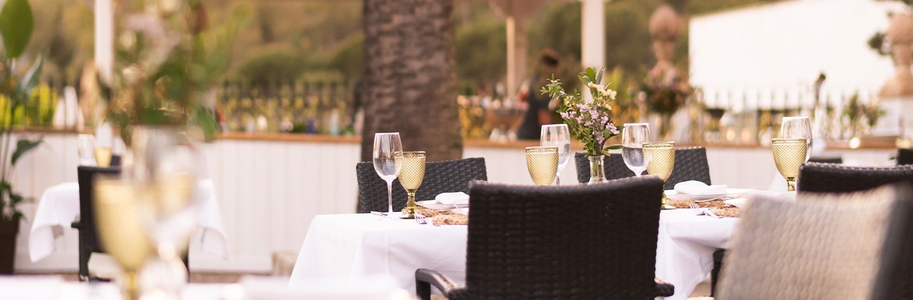 una mesa con copas de champán y un jarrón de flores