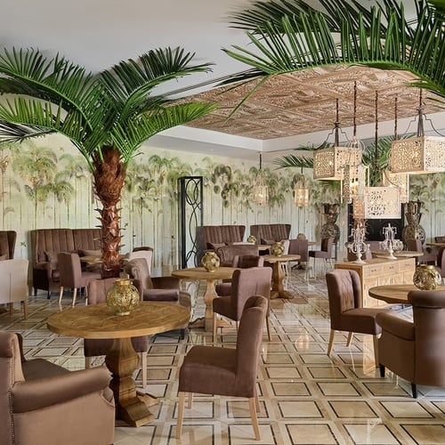 a restaurant with palm trees and tables and chairs
