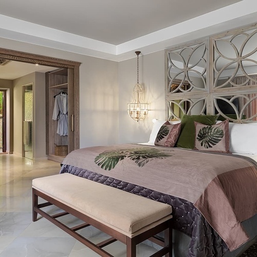 ein Schlafzimmer mit einem Bett und Spiegeln an der Wand