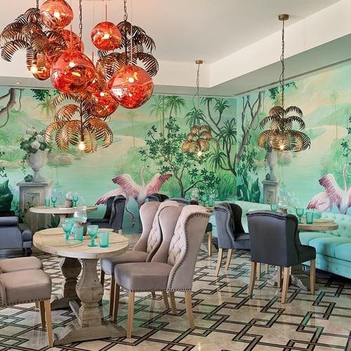a dining room with flamingos painted on the walls