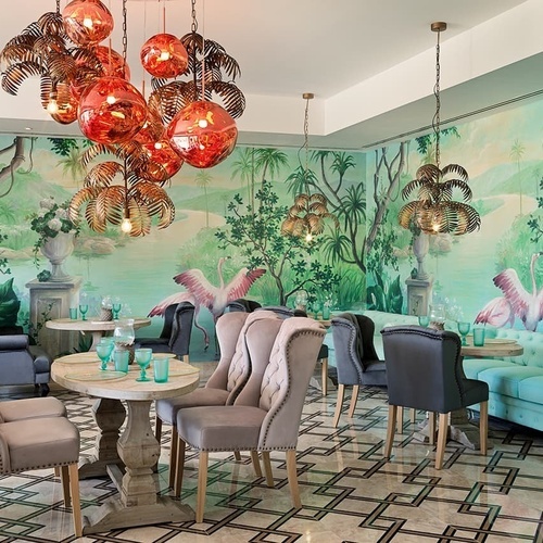ein Esszimmer mit Stühlen und Tischen und einem Wandbild mit Flamingos
