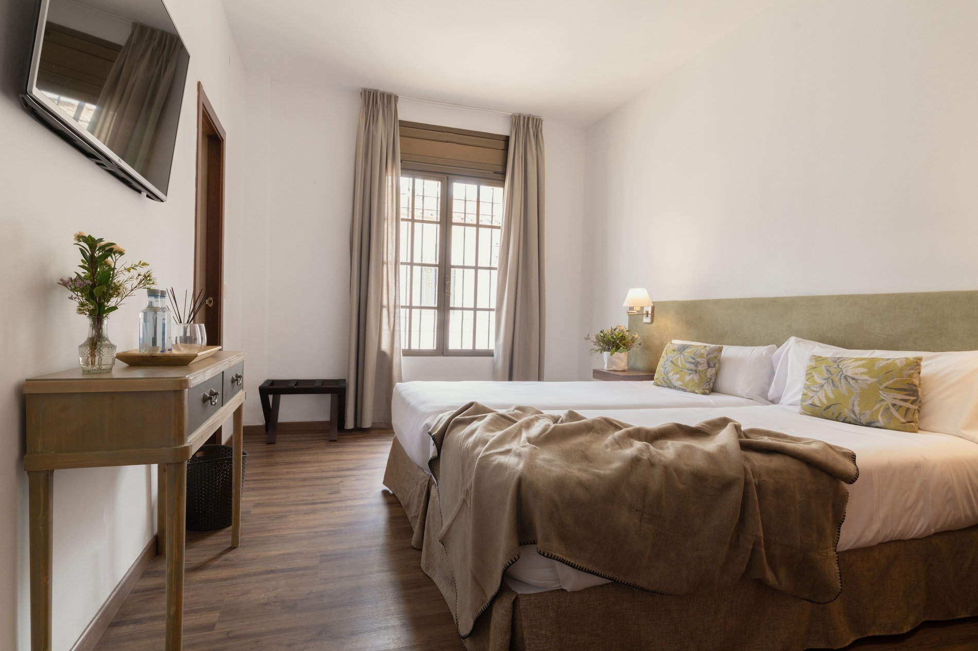 a hotel room with two beds and a flat screen tv