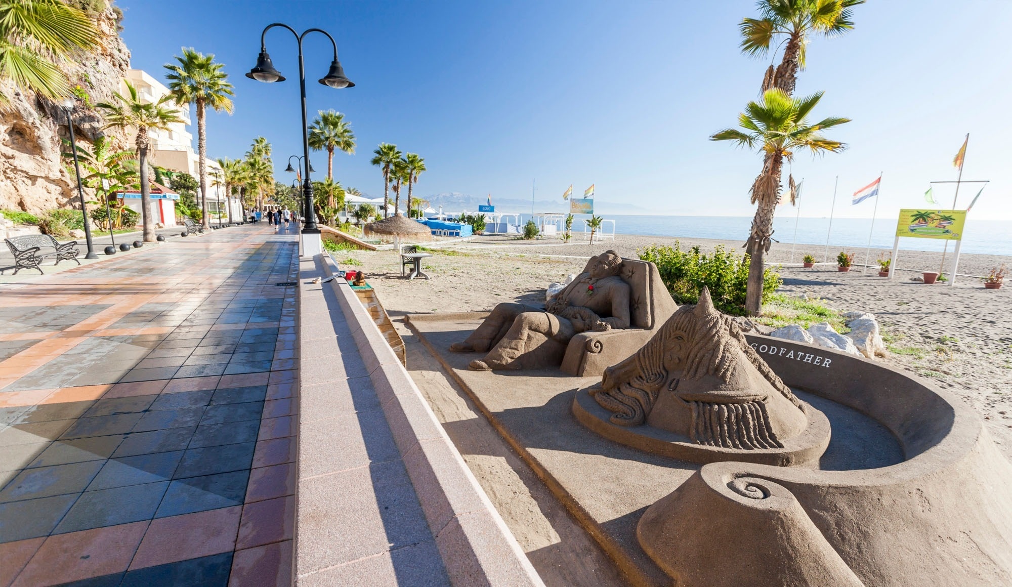 una escultura de arena en la playa con la palabra padrino