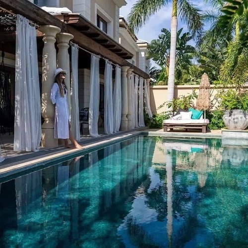 eine Frau in einem Bademantel steht neben einem großen Swimmingpool