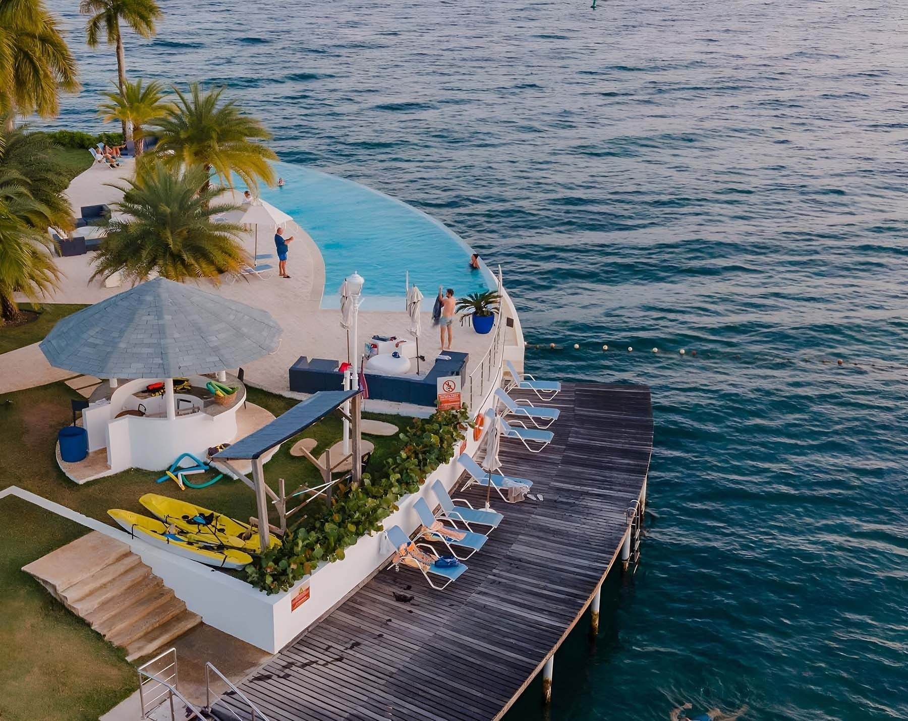 dos sillas y una mesa en un balcón con vista al océano