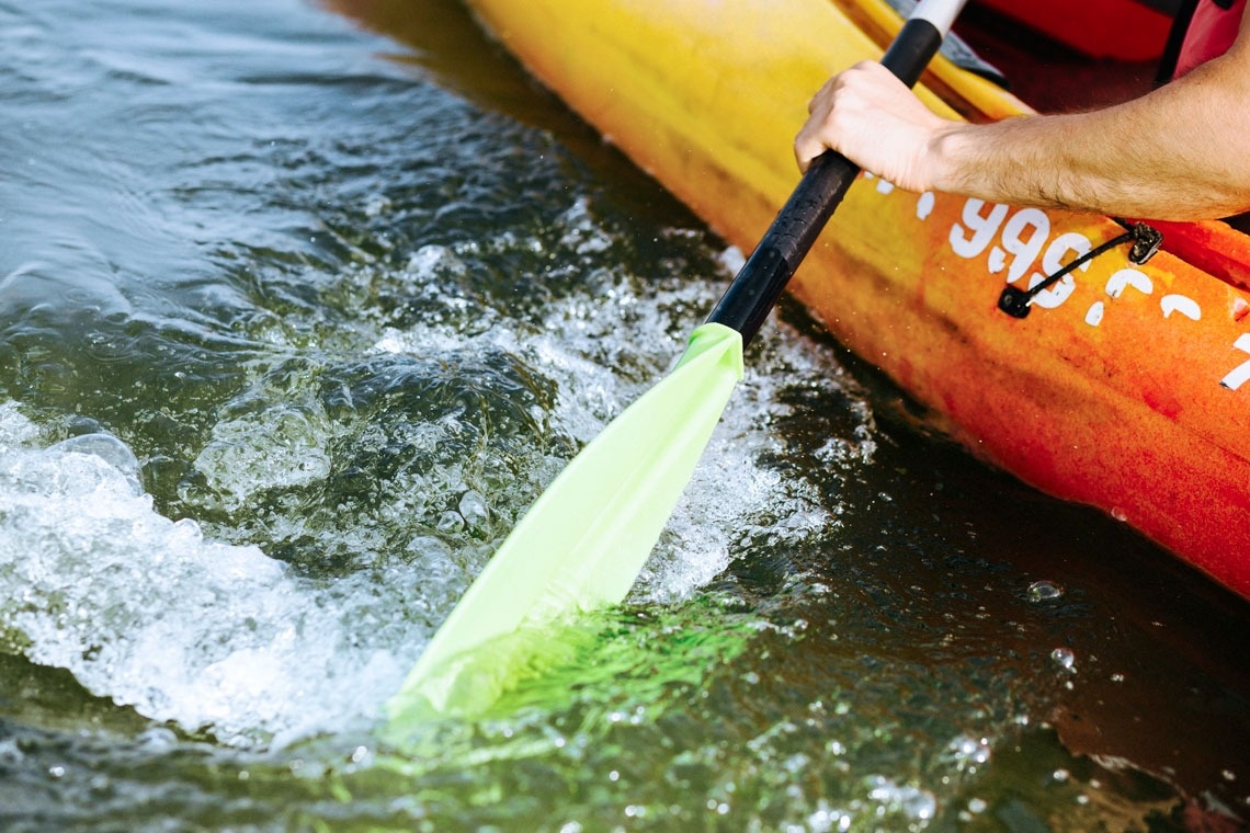 una persona rema en un kayak con el número 996 en la parte delantera