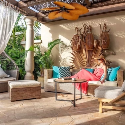 eine Frau in einem rosa Kleid sitzt auf einer Couch