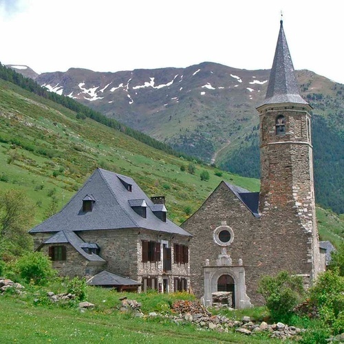 a stone building with a steeple and a mountain in the background