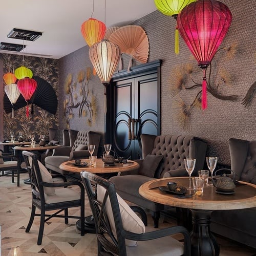 a restaurant with tables and chairs and lanterns hanging from the ceiling
