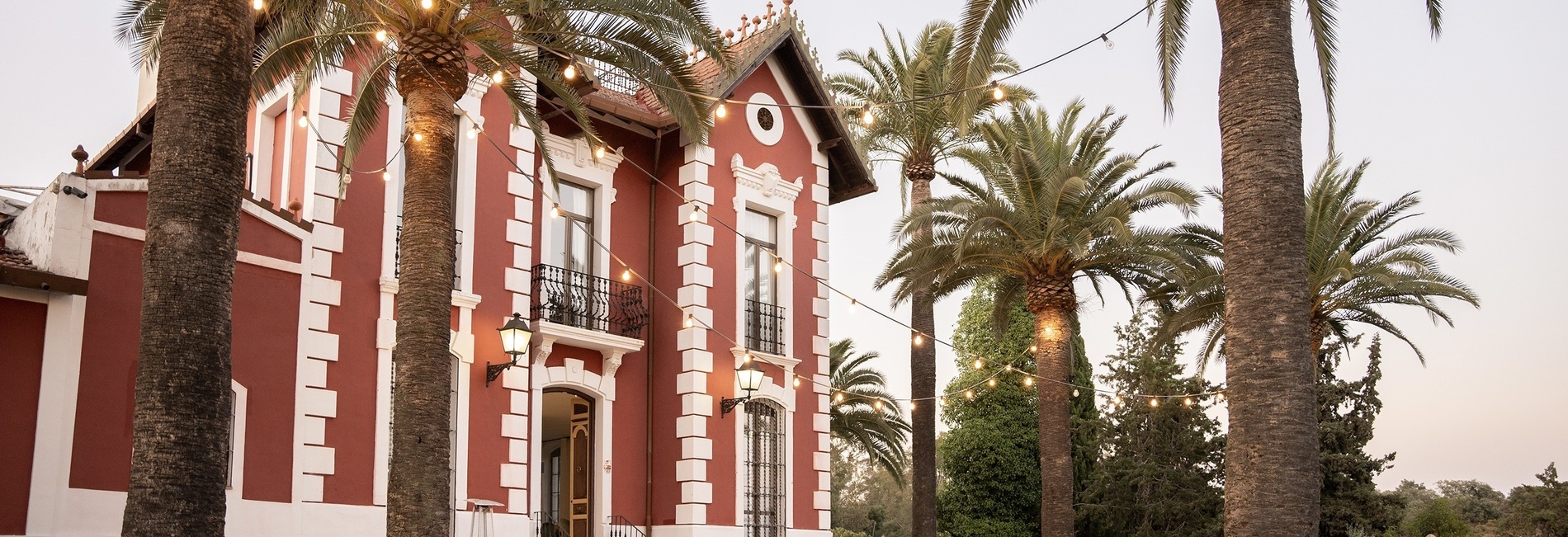 a red and white building with palm trees in front of it
