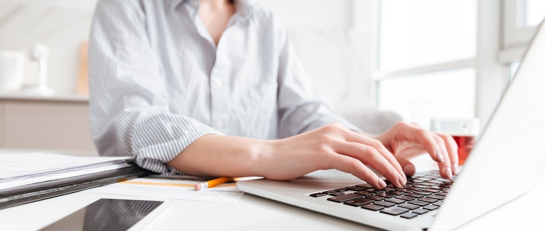una mujer está usando una computadora portátil y escribiendo en el teclado
