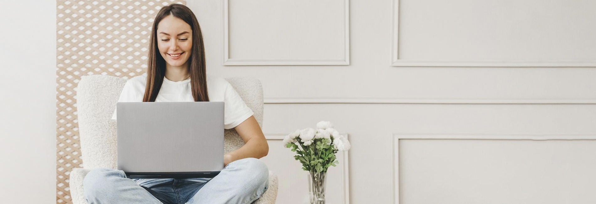 a woman is sitting in a chair using a laptop