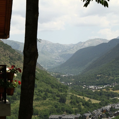 a balcony overlooking a valley with mountains in the background