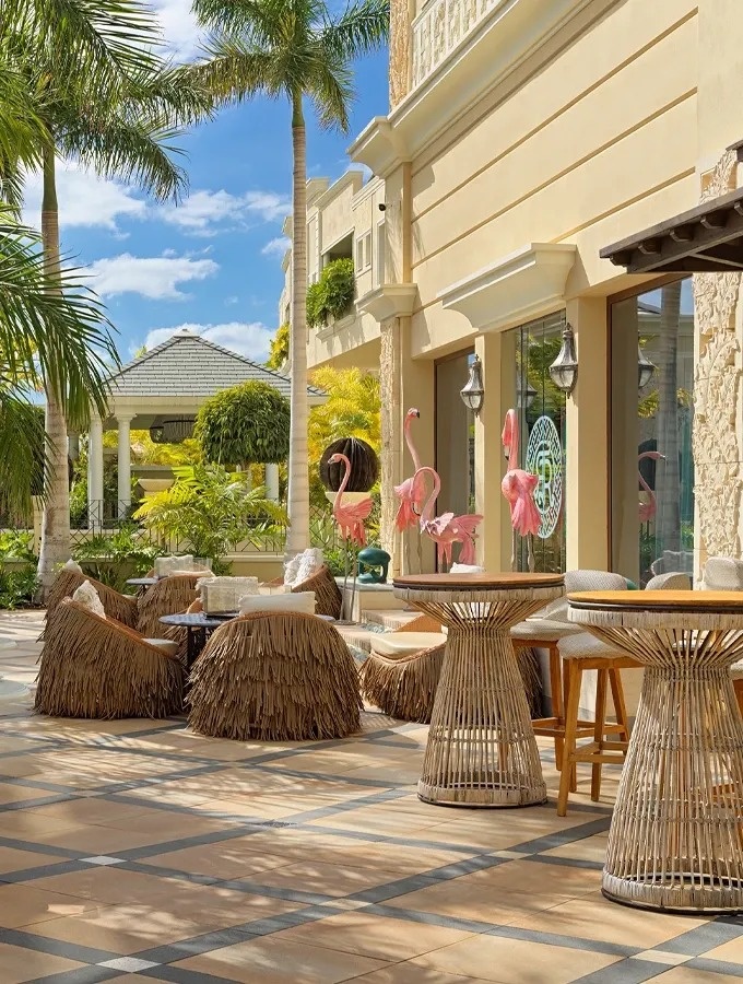 eine Frau in einem Hut sitzt am Rand eines Pools