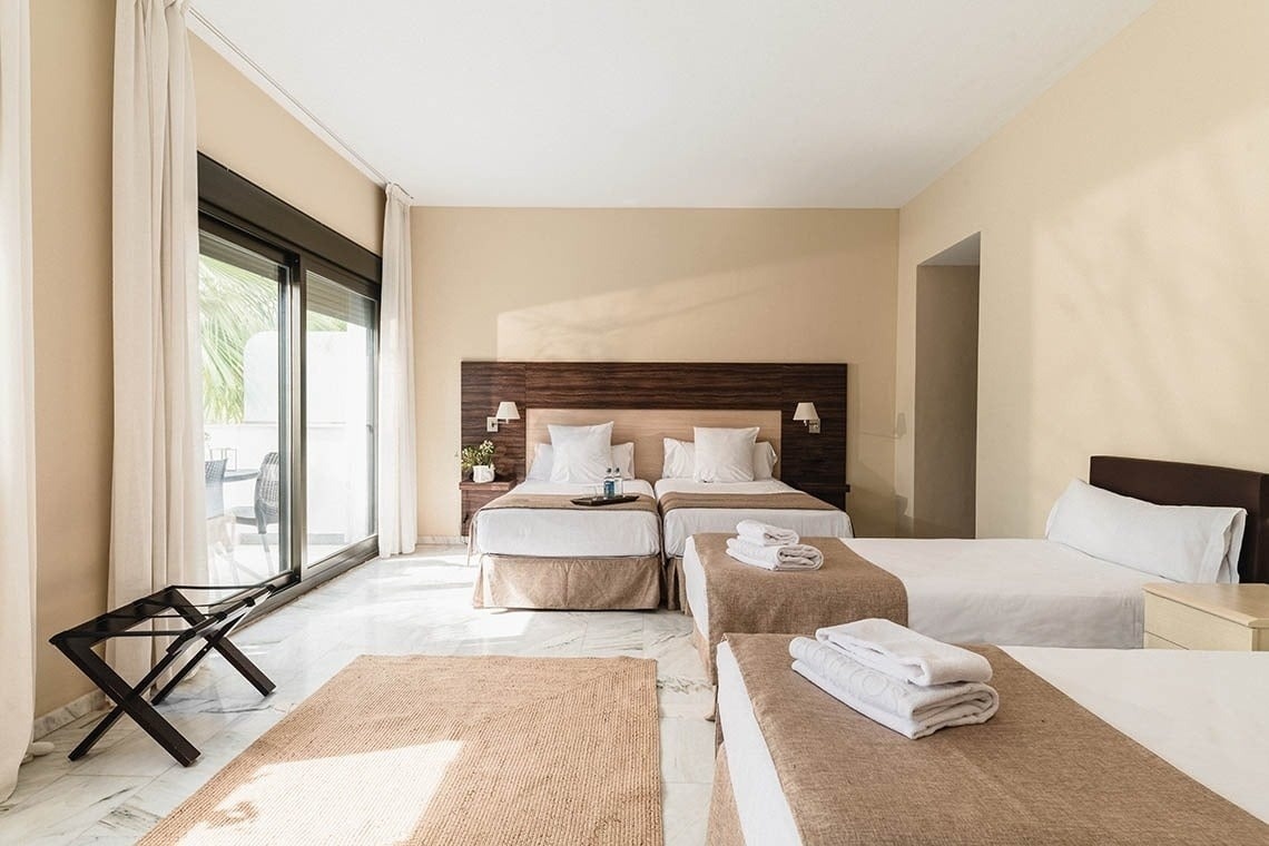 una habitación de hotel con dos camas y una mesa