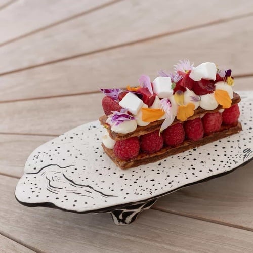 a dessert with raspberries and marshmallows on a white plate