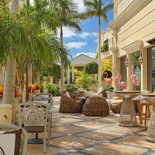 eine Terrasse mit Stühlen und Tischen und einer Bar