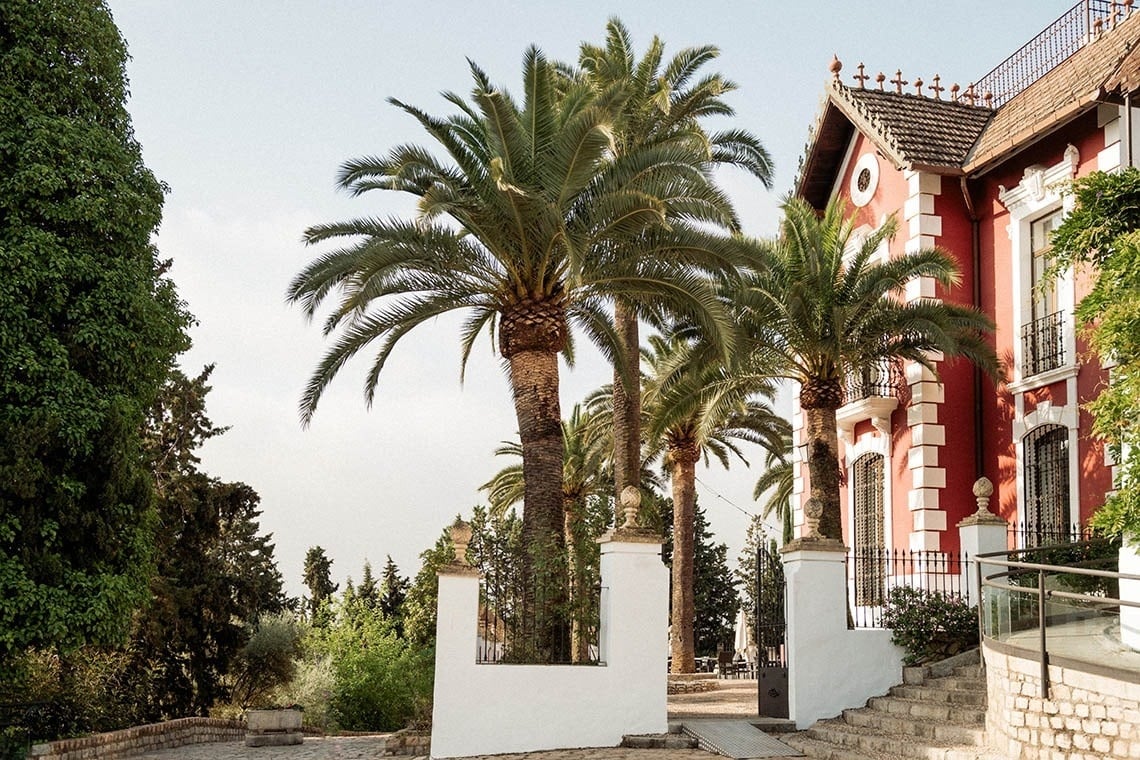 un edificio rojo y blanco con palmeras alrededor