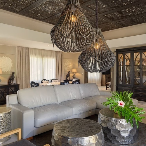 ein Wohnzimmer mit einem weißen Ledersofa und zwei Metalltischen