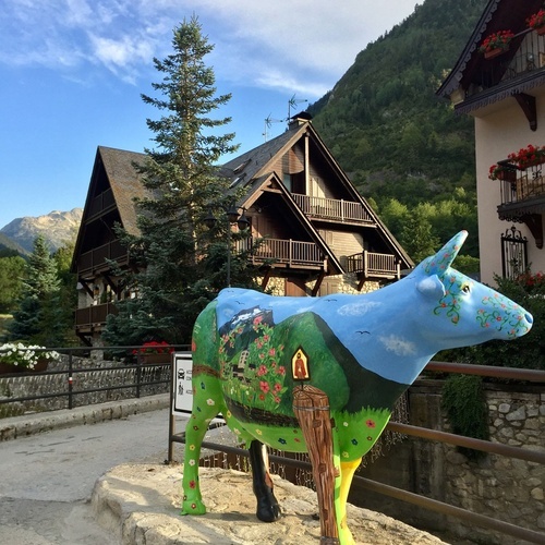 a statue of a cow with a house painted on it