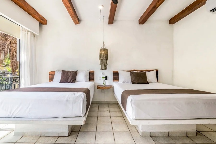 dos camas en una habitación con techo de madera