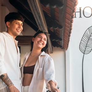 un hombre y una mujer se paran frente a un cartel que dice hotel banana