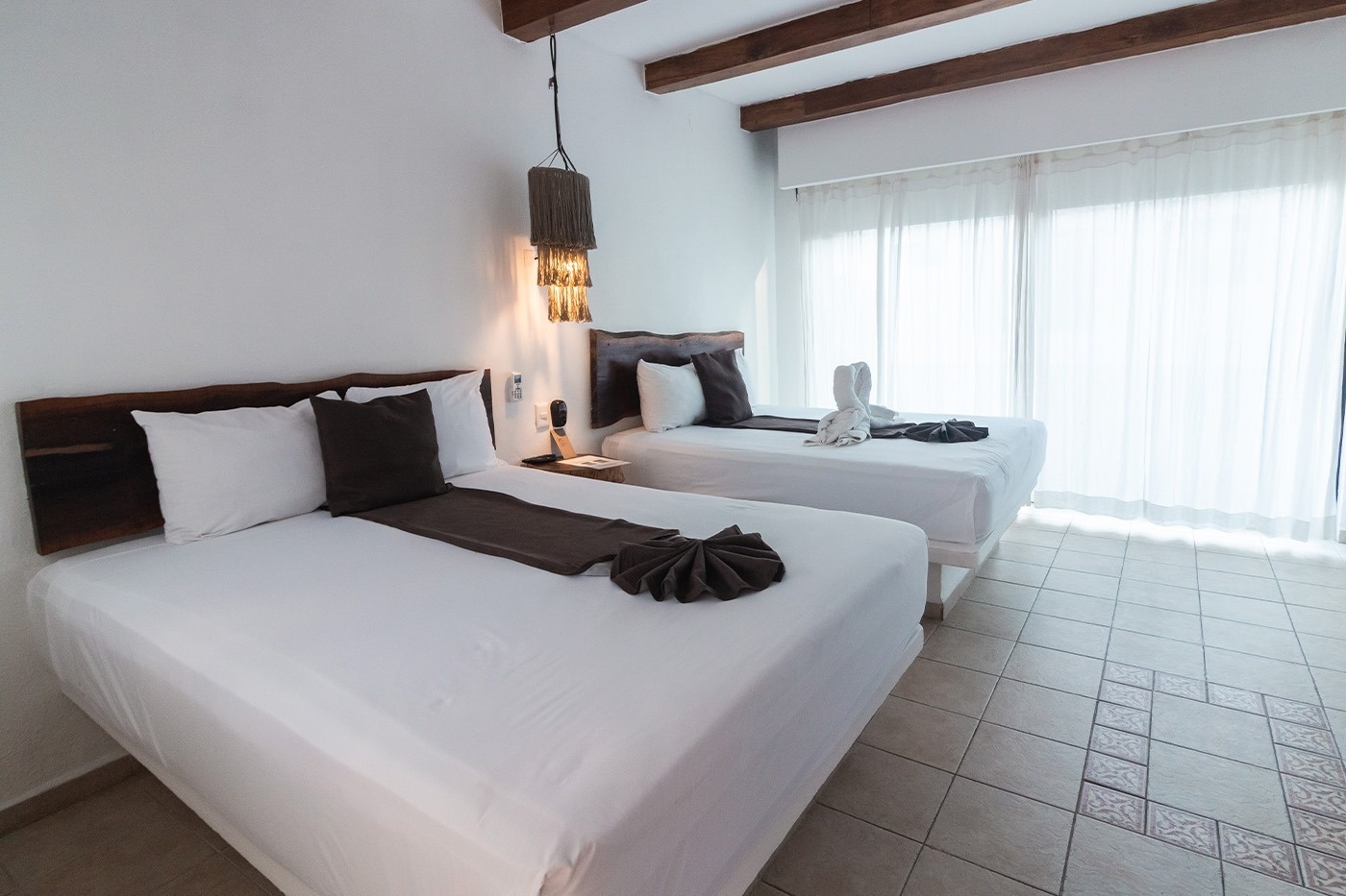 una habitación con dos camas y una gran ventana