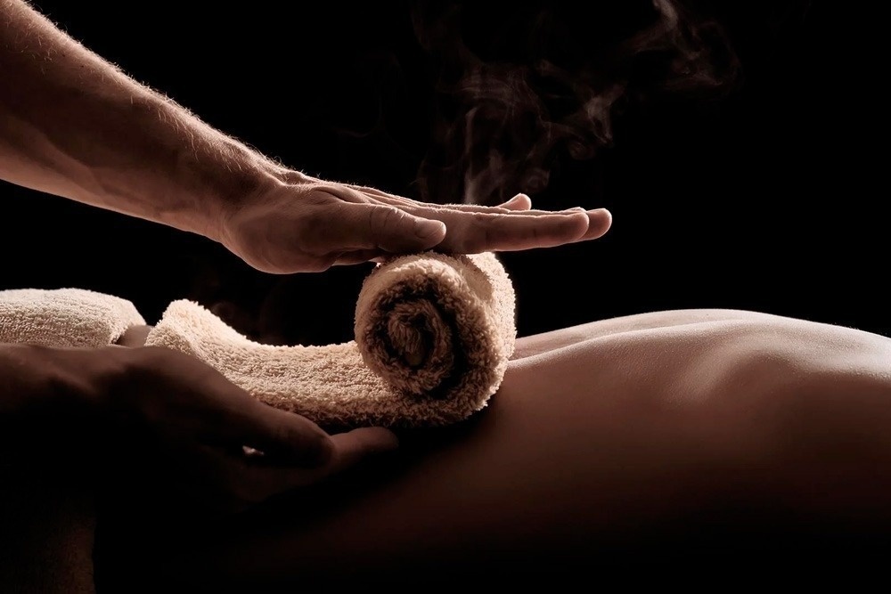 un hombre está dando un masaje a una mujer con una toalla