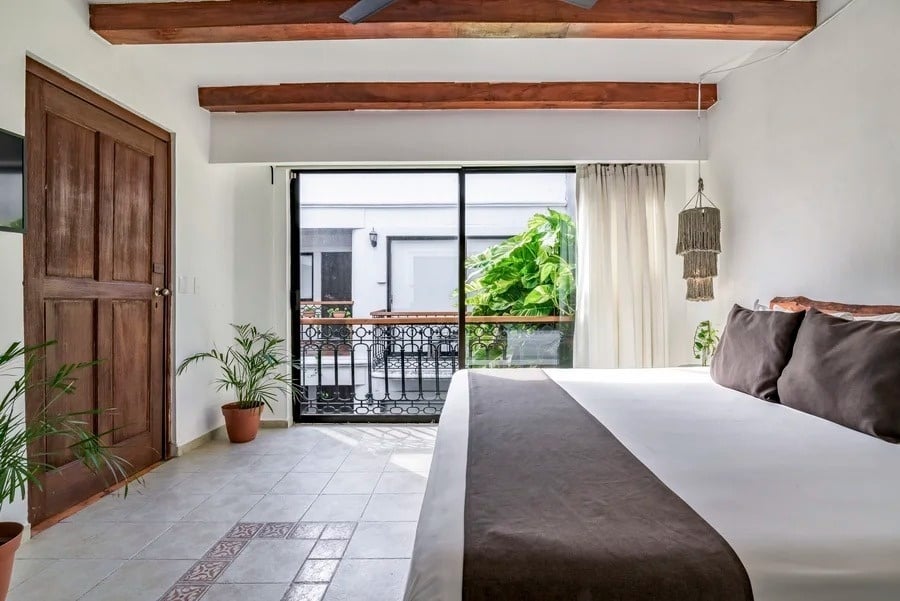 una habitación con una cama y una puerta de vidrio que conduce a un balcón