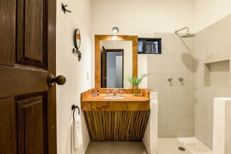 un baño con un lavabo de madera y un espejo