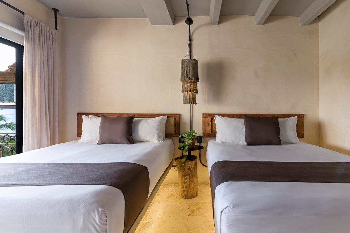 una habitación con dos camas y una lámpara colgante