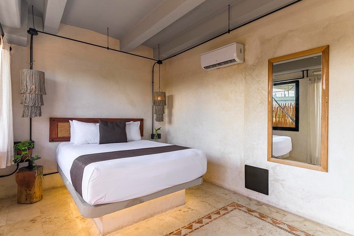 una habitación con una cama y un espejo en la pared