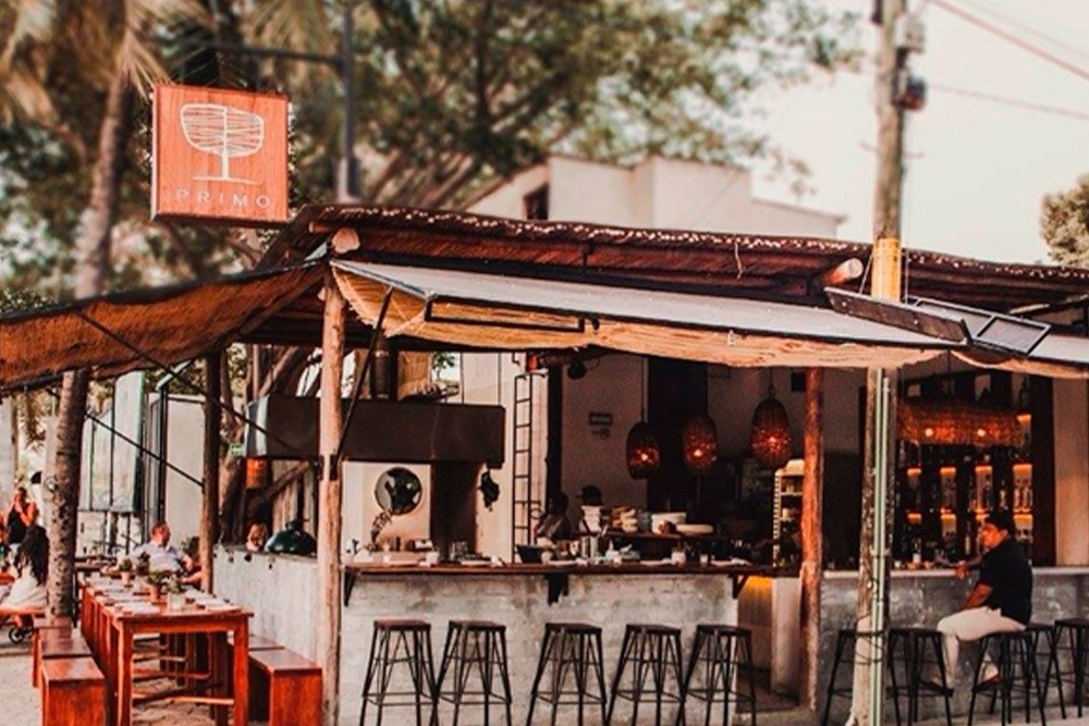 un grupo de personas se sienta en mesas frente a un restaurante llamado tigre