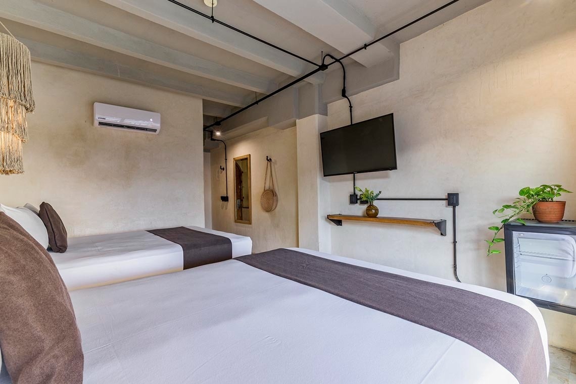 una habitación de hotel con dos camas y una televisión