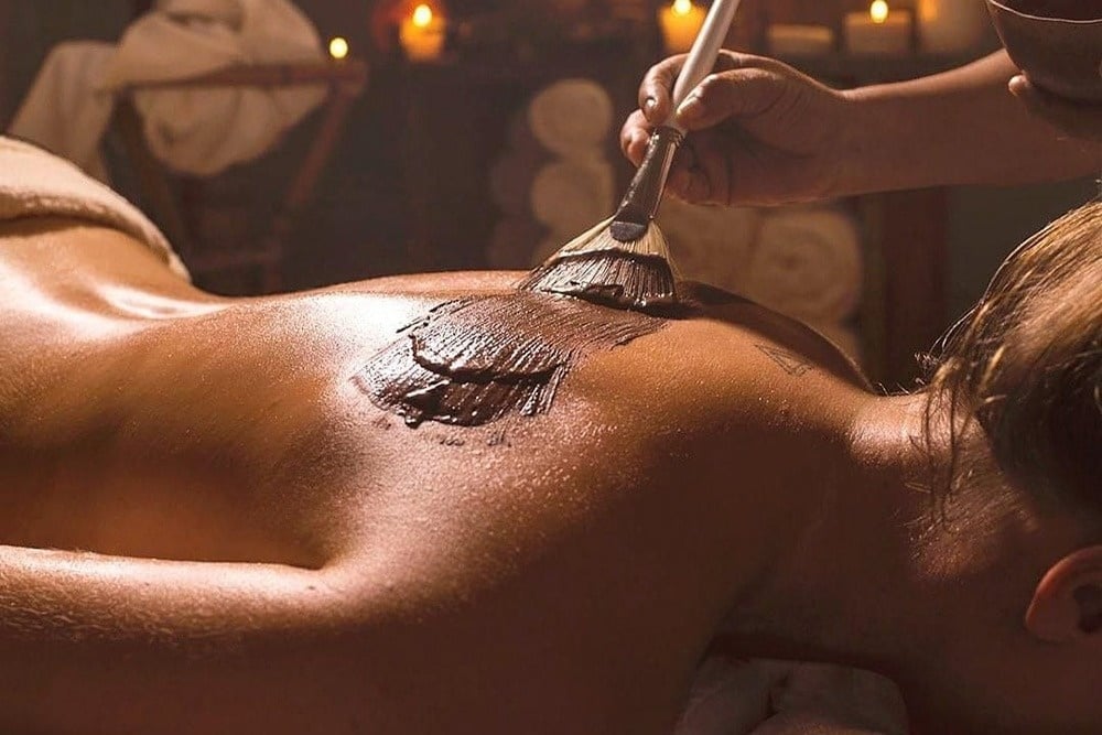 un hombre está dando un masaje a una mujer con una toalla