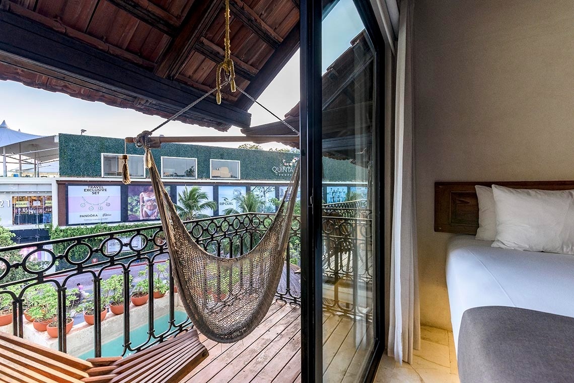 una habitación con una cama y una hamaca en el balcón