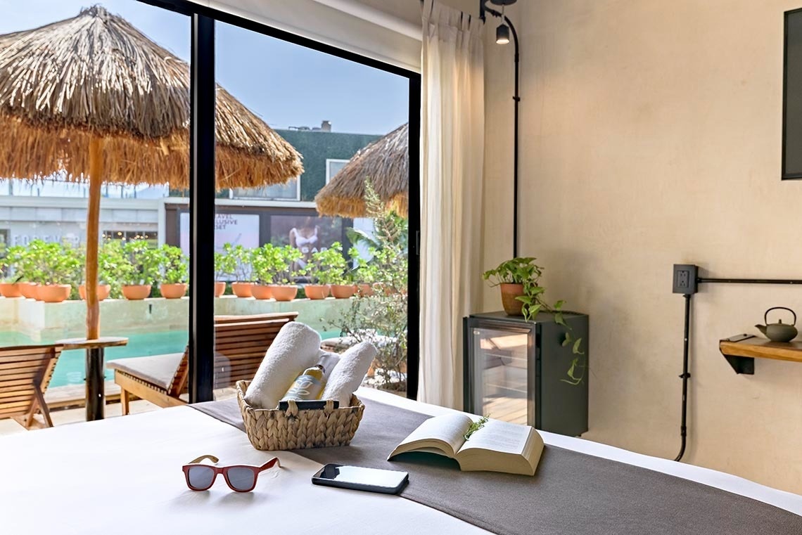 una cama con una canasta de toallas y un libro abierto