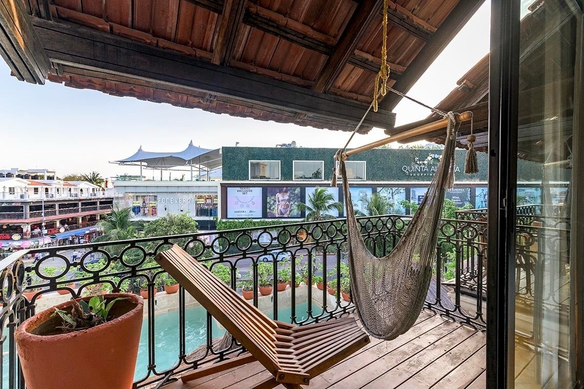 un balcón con una hamaca y un edificio que dice quintana roo