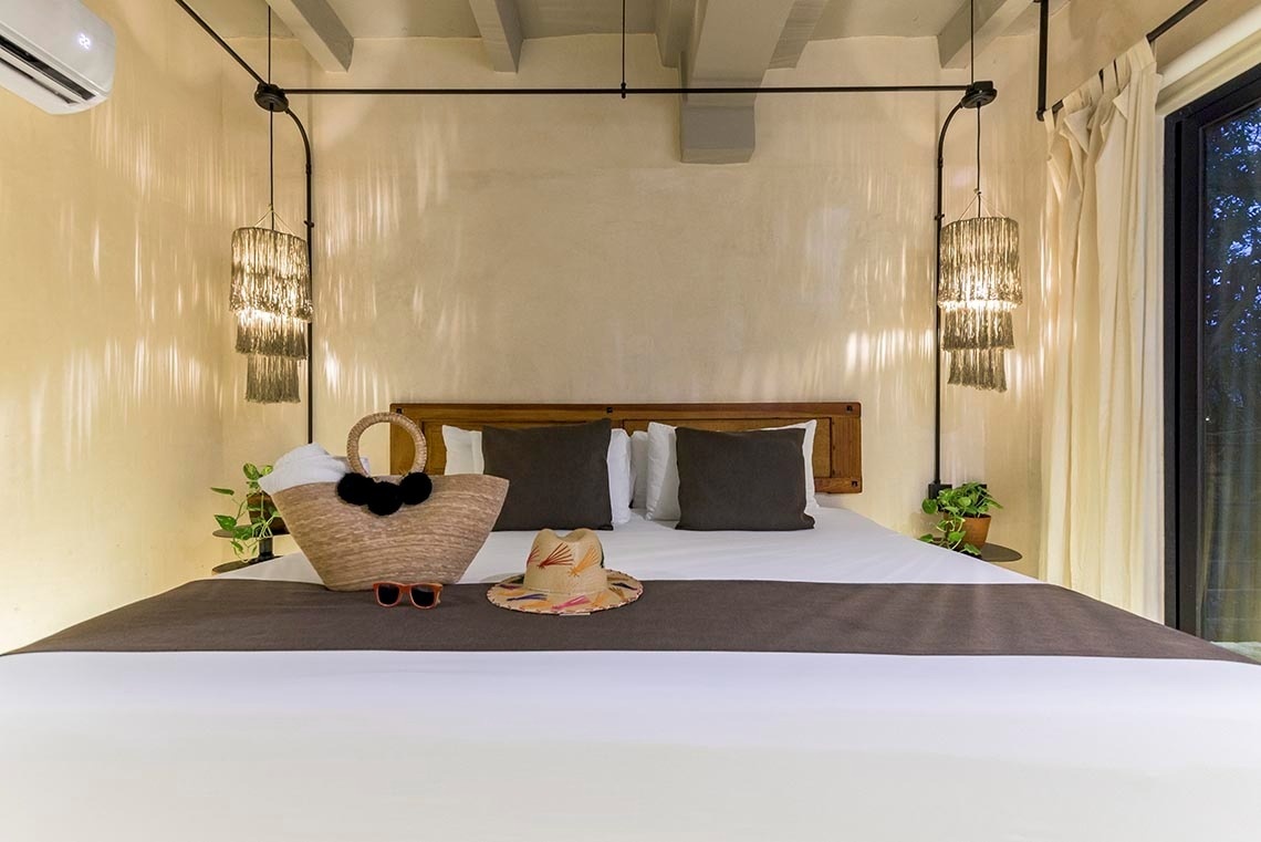 una cama con un sombrero y una bolsa de mimbre encima