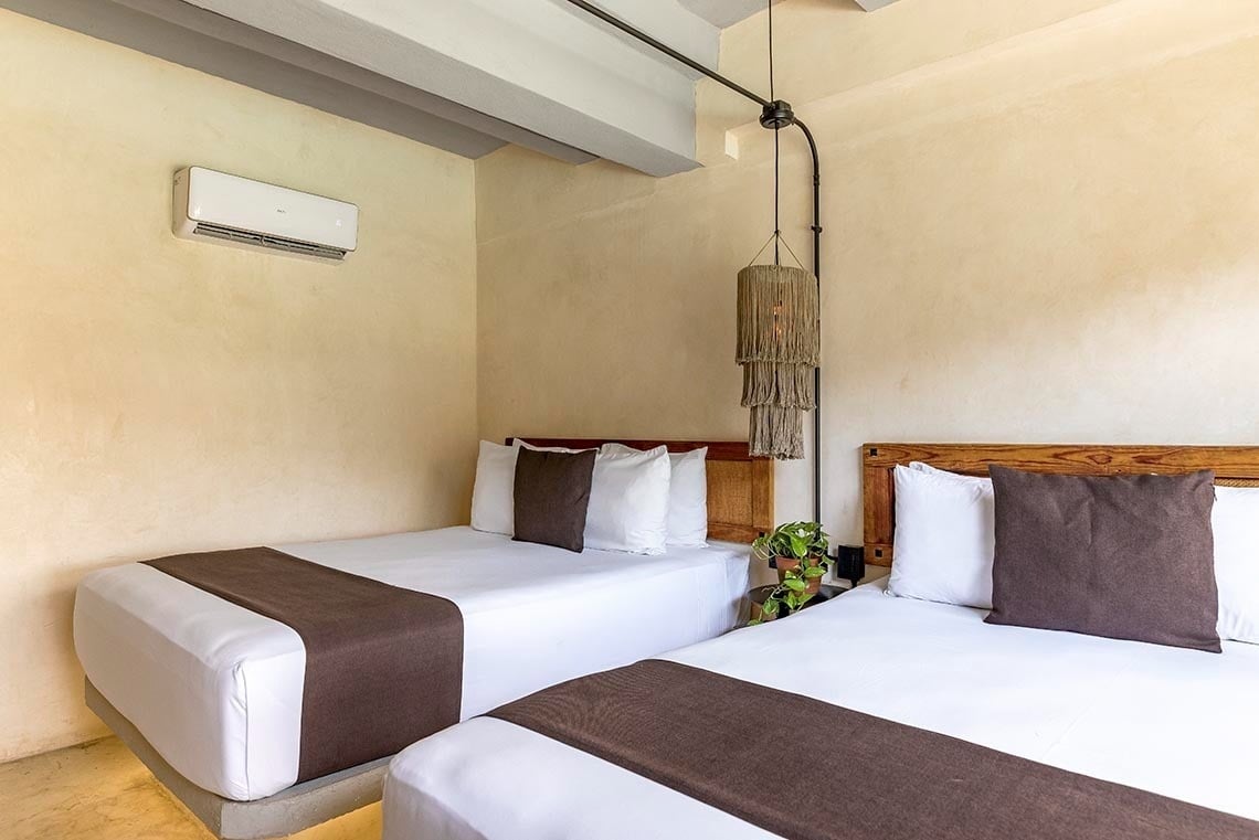 una habitación con dos camas y un aire acondicionado