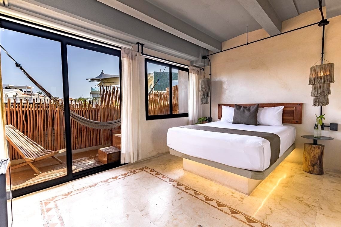 una habitación con una cama blanca y una hamaca