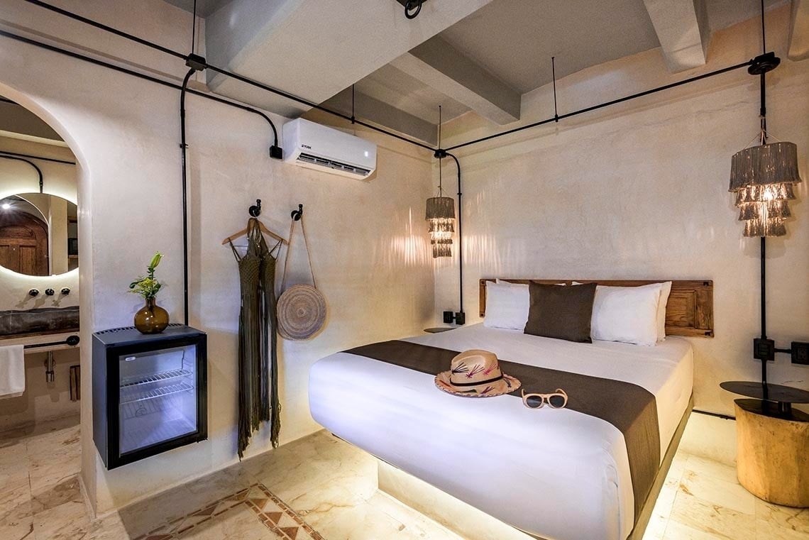 una habitación con una cama y una nevera pequeña