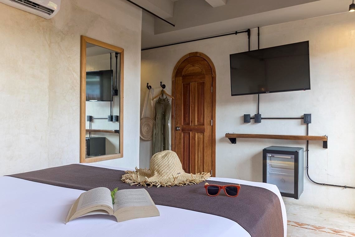 una cama con un sombrero de paja y un libro abierto